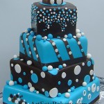 Three tier chocolate brown and blue polka dot cake with edible teddy bear topper